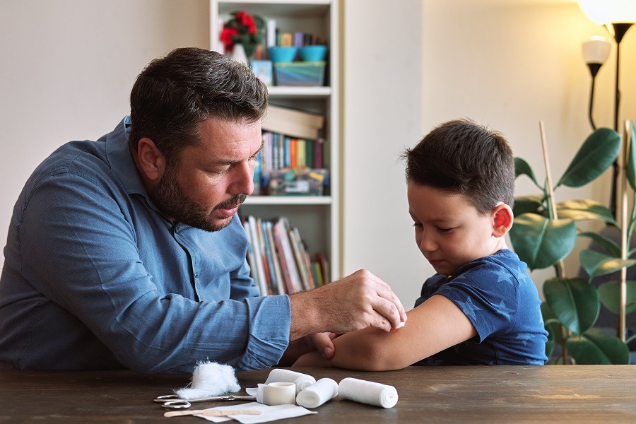 Man performs first aid on a young boy