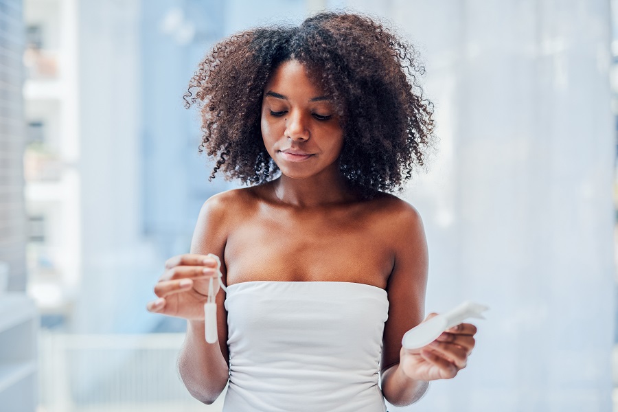 Woman holds sanitary towel and tampon