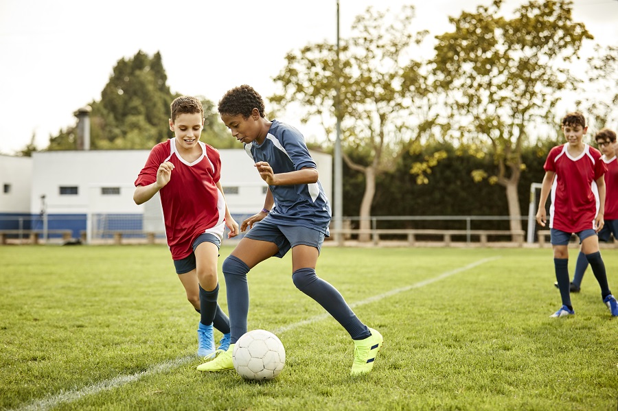 Young teenage boys playing football