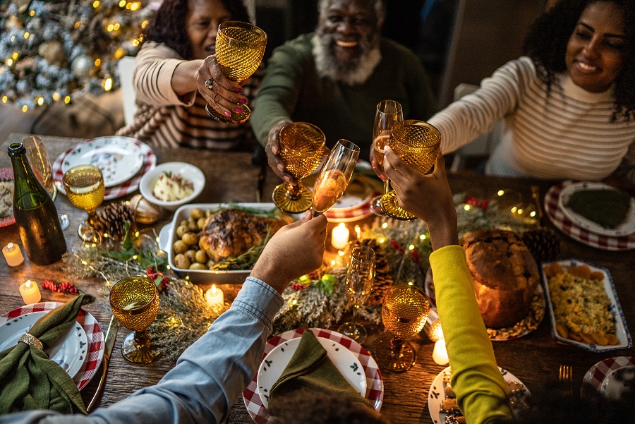 Family share a toast at Christmas with food, drink and decorations on the table