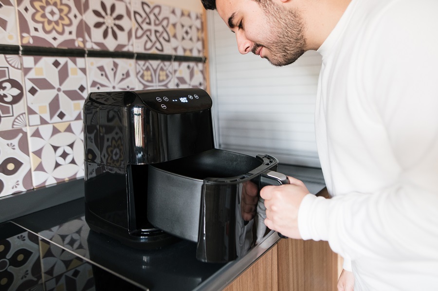 Man cooking with a black air fryer