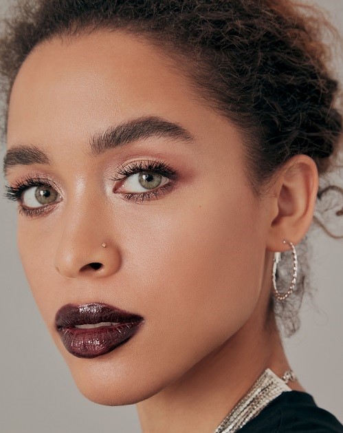 model wearing dark black and red lipstick looking into camera 