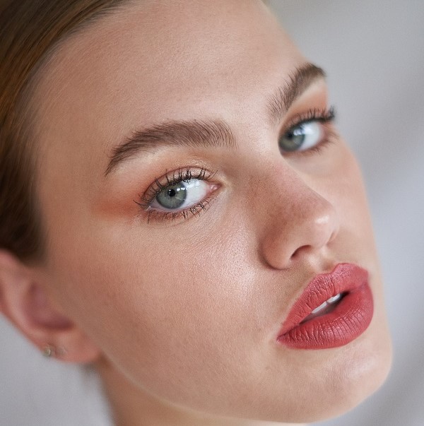 model looking at camera wearing pink lipstick 