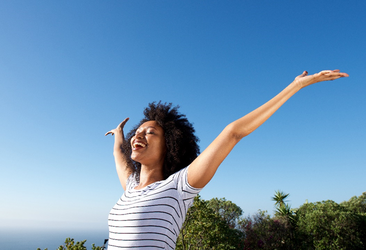 woman opening her arms in the sun