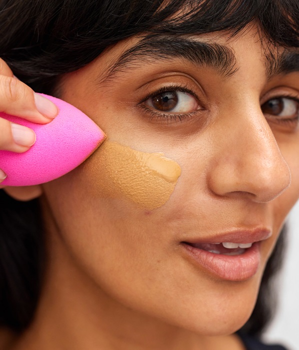 woman applying foundation with blender