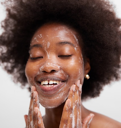 woman applying foam cleanser to wash face 