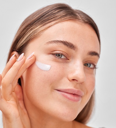 woman applying serum to clean face 