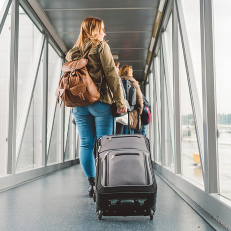 lady with a suitcase walking through airport