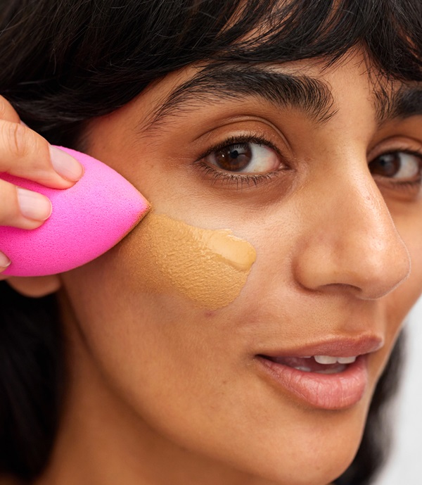 model applying foundation with sponge